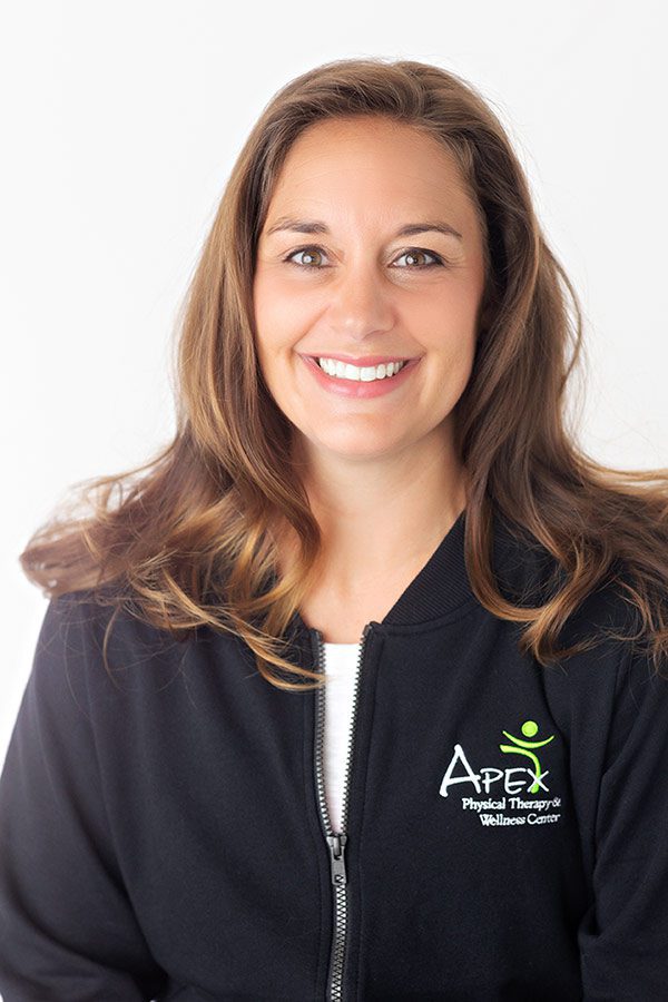 A smiling woman with long hair wearing a black zip-up jacket with an 