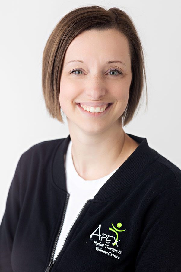 A professional portrait of a smiling woman named Emma Neinaber wearing a black jacket with an 