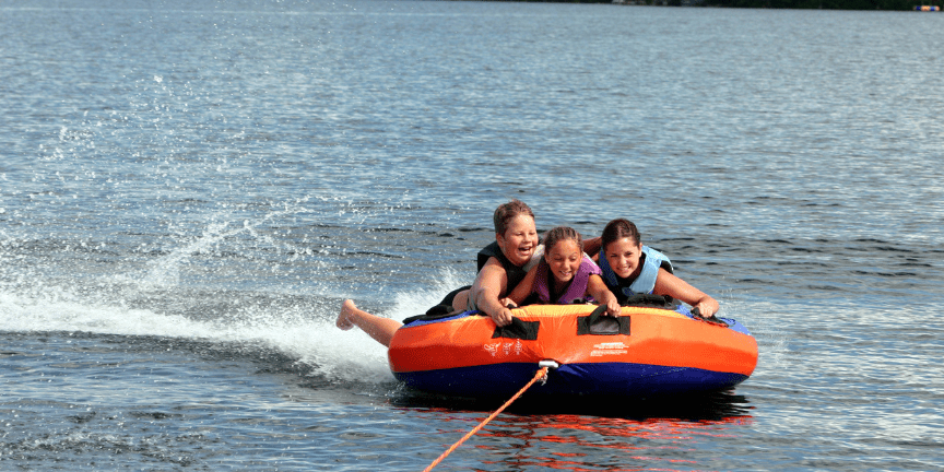 3 kids tubing on lake