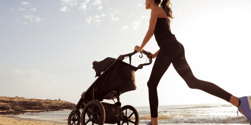 young mom running with stroller on beach